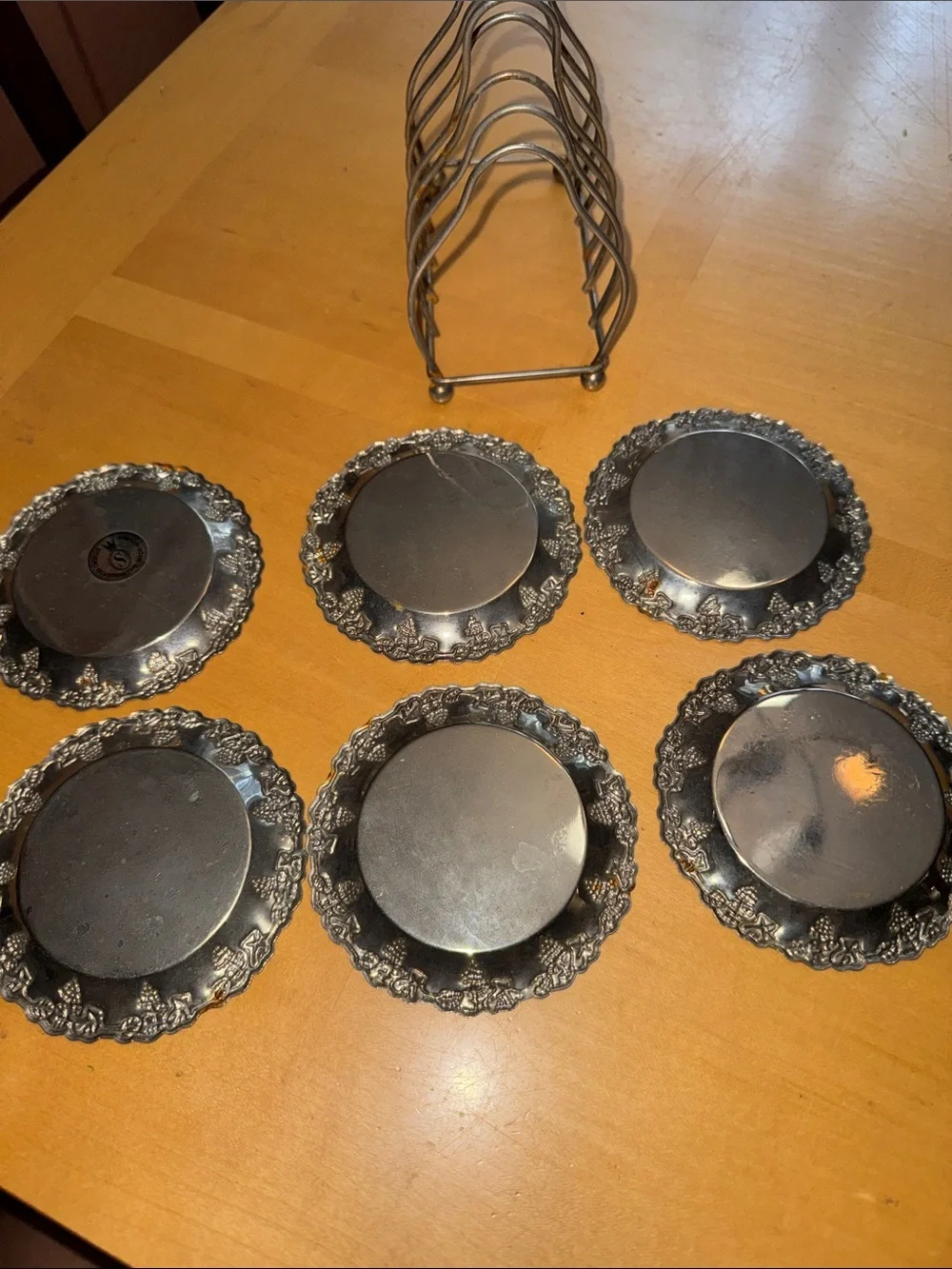 six vintage silver-plated drink coasters with ornate, embossed floral